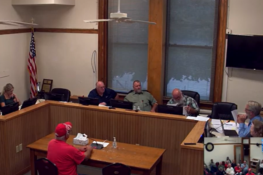 A room filled with people speaking to a podium.