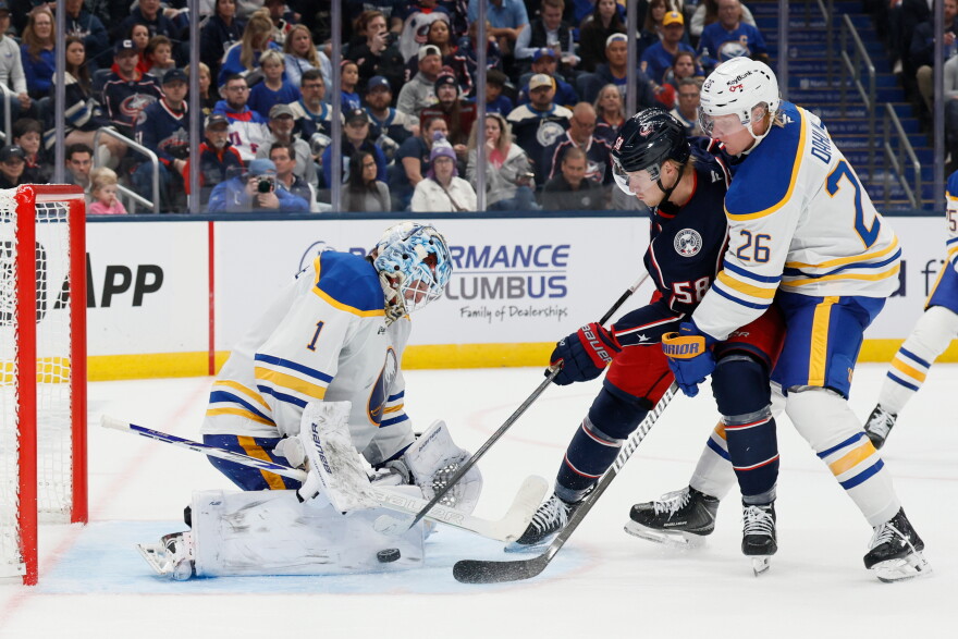 The Buffalo Sabres' Ukko-Pekka Luukkonen, left, makes a save against Columbus Blue Jackets' Danton Heinen, center, as Sabres' Rasmus Dahlin (26) defends during the second period of an NHL hockey game, Thursday, Oct. 1, 2026, in Columbus, Ohio.