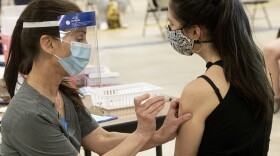 This Thursday, April 8, 2021 file photo shows Kent State University student Regan Raeth of Hudson, Ohio, has her COVID-19 vaccination administered by Kent State nurse Kristen Barath in Kent, Ohio.