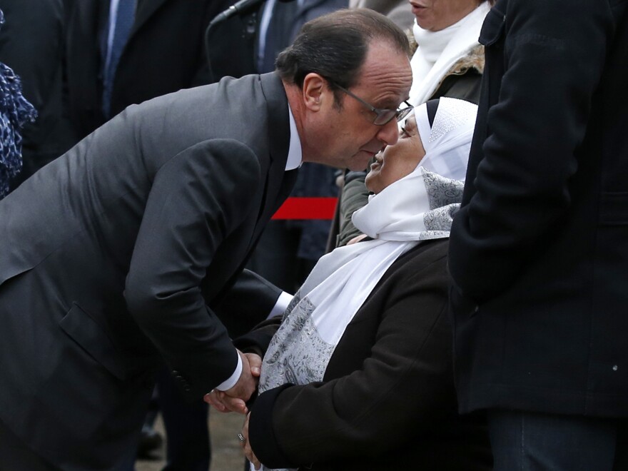 French President Francois Hollande kisses the mother of late police Officer Ahmed Merabet during commemorations in Paris on Tuesday. Hollande paid tribute to Merabet, who was killed a year ago as he tried to chase down the gunmen responsible for the Charlie Hebdo attacks.