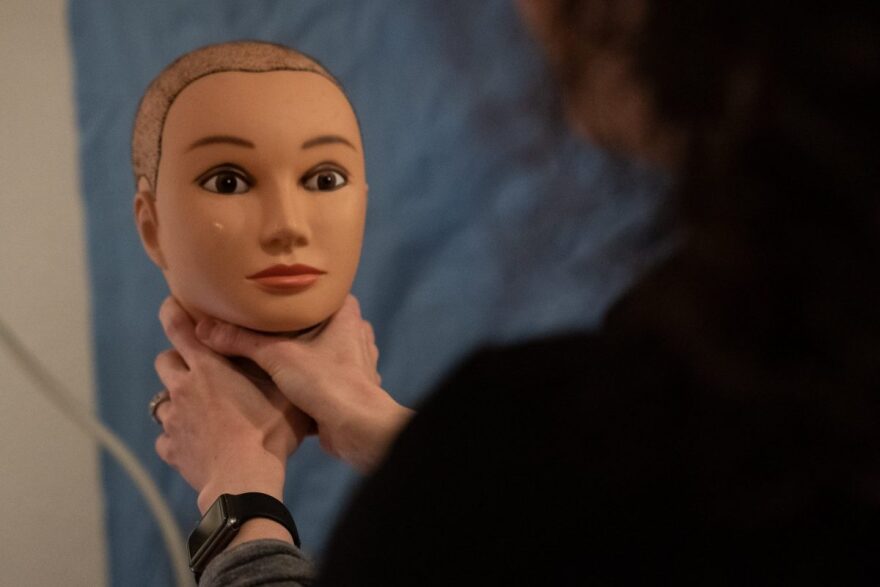 Jessica Collett, nurse examiner at the Women’s Resource Center in Norman, demonstrates the dangers of strangulation on a mannequin head at the Rape Crisis Center. Nurses offer the mannequins to victims when they are asked to recount details of their attac