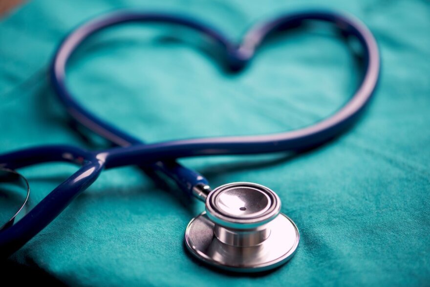 A stethoscope shaping a heart on a medical uniform, closeup