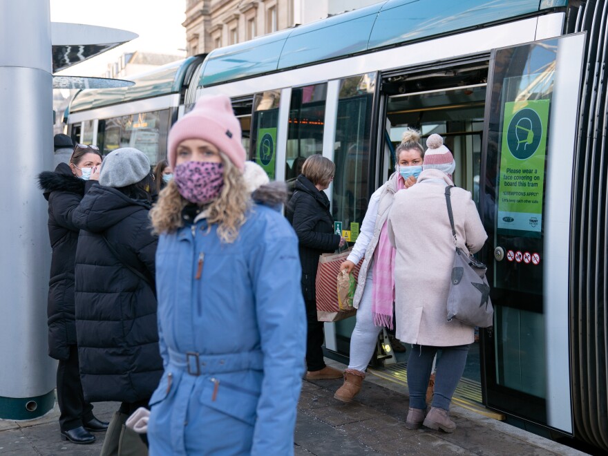 People step off a tram in Nottingham, England, the city where one of the two cases of the Omicron variant of COVID-19 were identified last week.