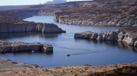 A boat cruises along Lake Powell near Page, Ariz., on July 31, 2021. Seven states in the U.S. West are facing a deadline from the federal government to come up with a plan to use substantially less Colorado River water in 2023. The U.S. Bureau of Reclamation is expected to publish hydrology projections on Tuesday, Aug. 16, 2022, that will trigger agreed-upon cuts to states that rely on the river. Prolonged drought, climate change and overuse are jeopardizing the water supply that more than 40 million people rely on.