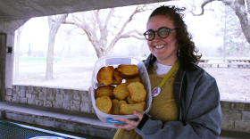 Jenny Pierce, the head of People's Pride ICT, holds a tray of garlic bread for their event "Gays Eating Garlic Bread in the Park."