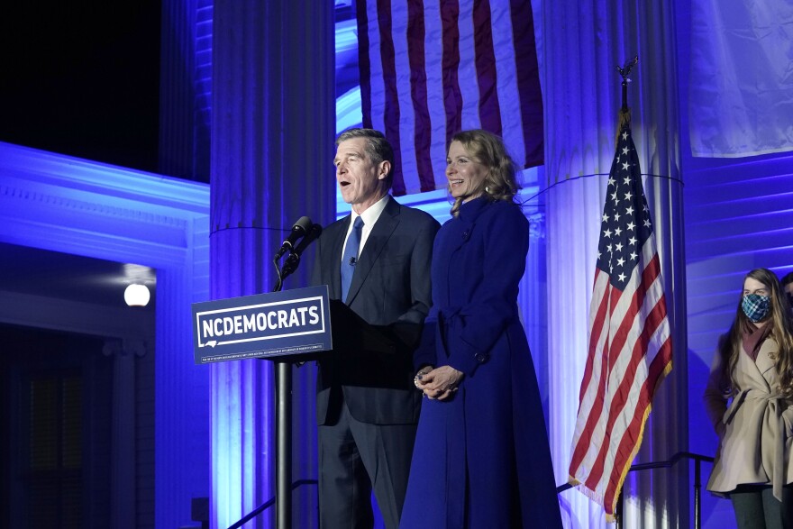 North Carolina Gov. Roy Cooper, joined by his wife Kristin, speaks after being declared winner over Republican Dan Forest in the governor's race in Raleigh, N.C., Tuesday, Nov. 3, 2020.