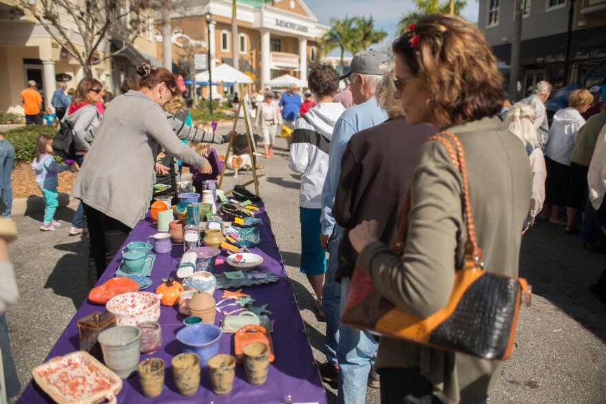 Woman eyes crafts during Lakewood Ranch Fine Art Festival.