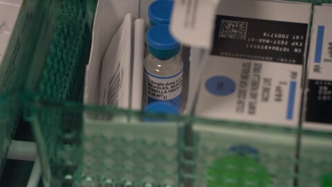 Vials of the combination measles, mumps and rubella vaccine are seen in a fridge.
