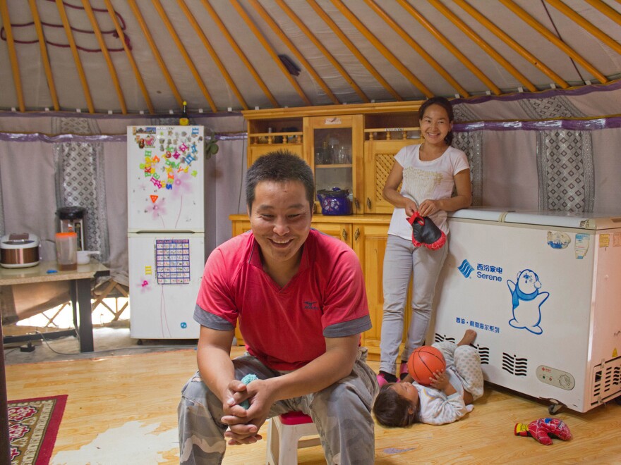 Gamsukh's company foreman, Chingis sits in his family's ger with his wife, Suydaa, and son Burkas, 3.