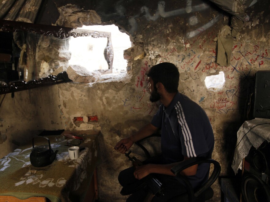 A rebel fighter keeps watch for government troops in Aleppo on Sunday.