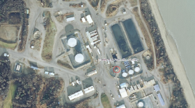 An aerial view of an oil production facilities shows a series of buildings near the Cook Inlet waters