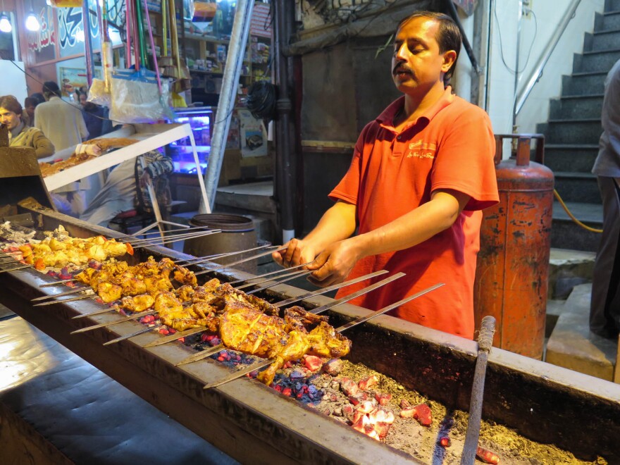 A chef cooks chicken in Lahore's Anarkali Food Street, a favorite eating place in a food-mad Pakistani city.