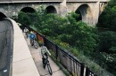 People bike along an off-road trail above the Genesee River