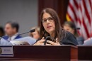 A woman sits behind a large desk in Florida House of Representatives chamber 