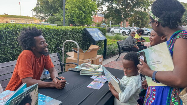 Author and illustrator Nikkolas Smith chats with fans during a book signing on Wed., Aug 26 at Fort Monroe in Hampton. Smith is a New York Times best-selling children's author and Hampton University graduate.