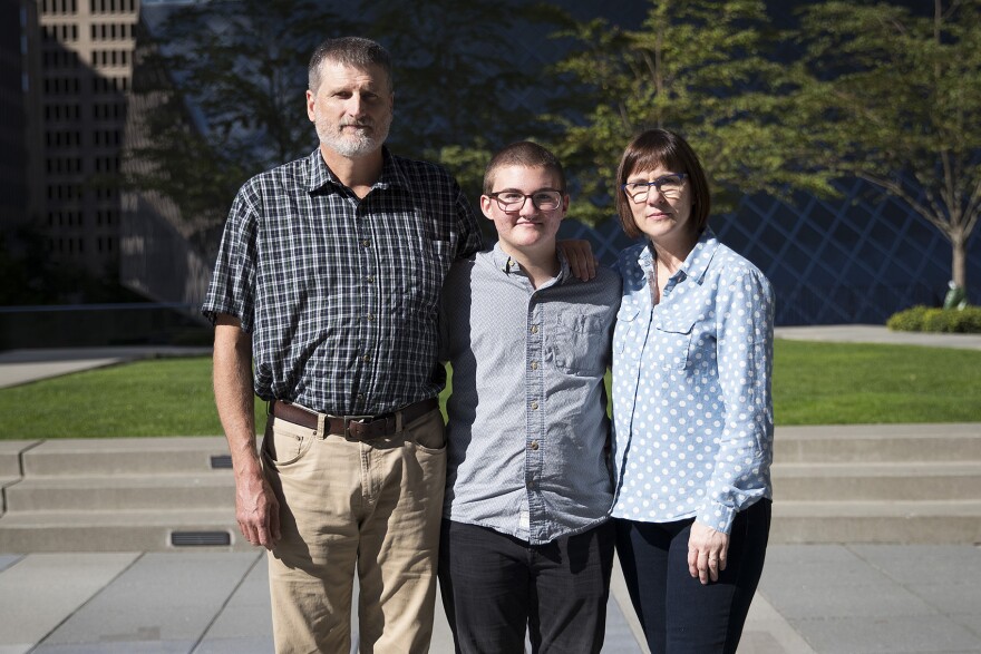 From left, Mark, Paxton and Cheryl Enstad pose for a portrait on Thursday, October 5, 2017, outside of the ACLU of Washington on 9th Ave., in Seattle. 