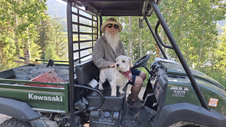 Shane Tucker and his dog Percy do the rounds of the campground at Pearl Lake, Colorado. One of the camp host's responsibilities is cleaning out fire pits when campers leave.