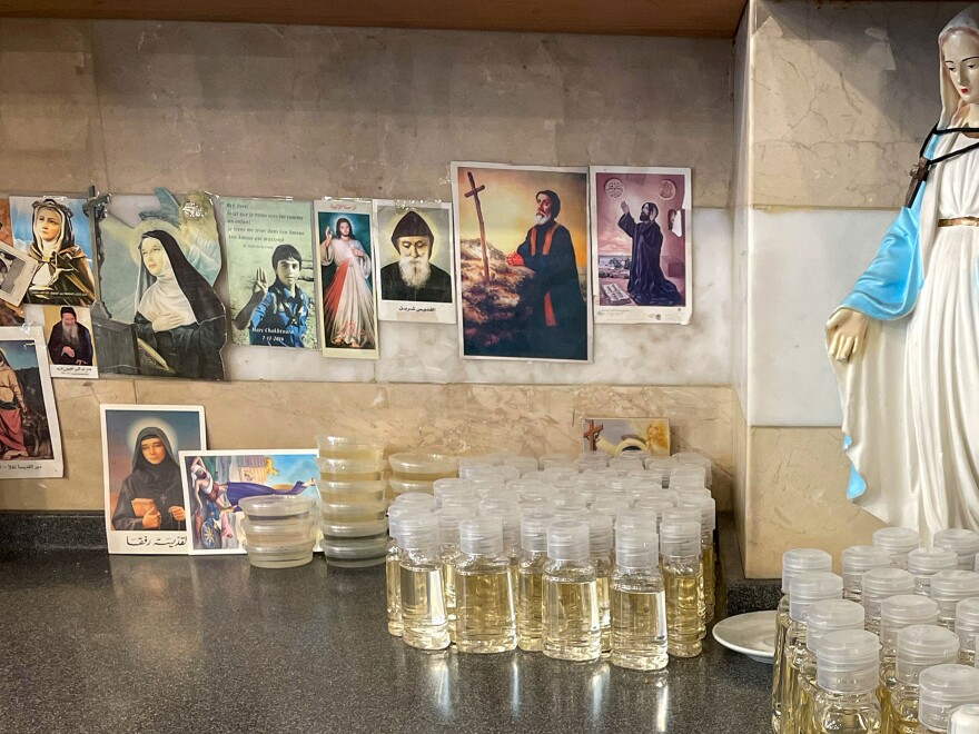 Bottles of sweet syrup infused with rosewater sit alongside Christian saints and figures in one corner of the shop.<a href="https://files.slack.com/files-pri/T031C6G0U-F05BF93P84S/download/sweets.pdf?origin_team=T031C6G0U" target="_blank" data-qa="download_action" data-sk="tooltip_parent" data-remove-tab-index="true"></a>