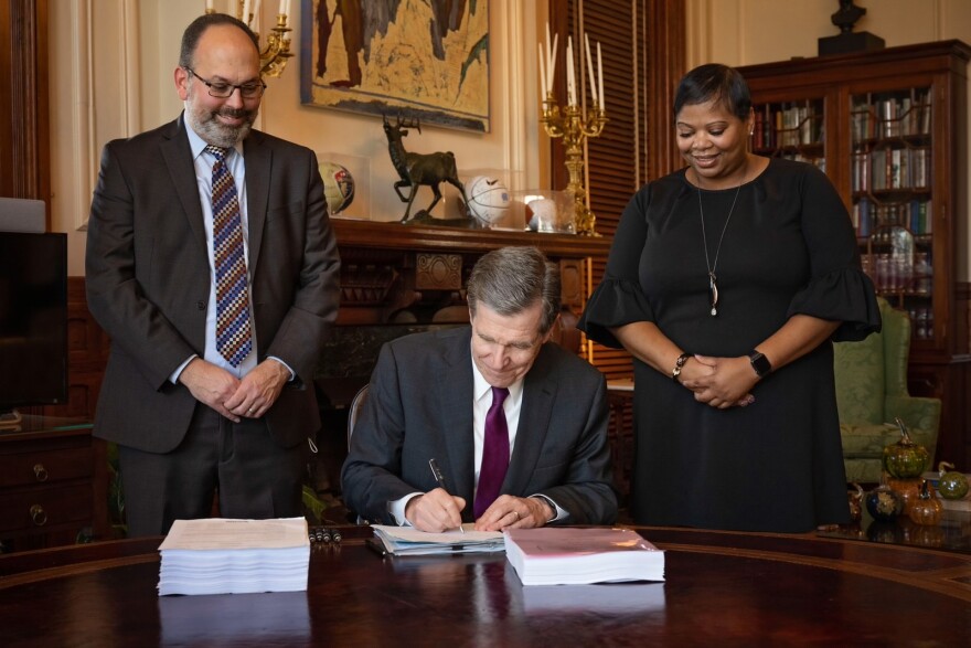  Gov. Roy Cooper signs the North Carolina state budget into law.