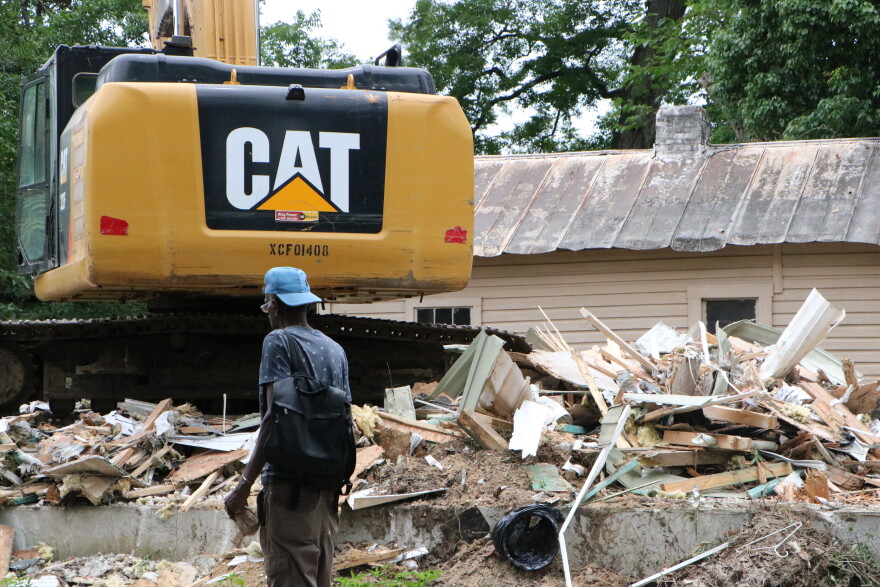 A passerby looks on as houses along Still Ct. are demolished to make way for an extension of FAMU Way. The project is a joint effort between the City of Tallahassee and intergovernmental agency Blueprint 2000.