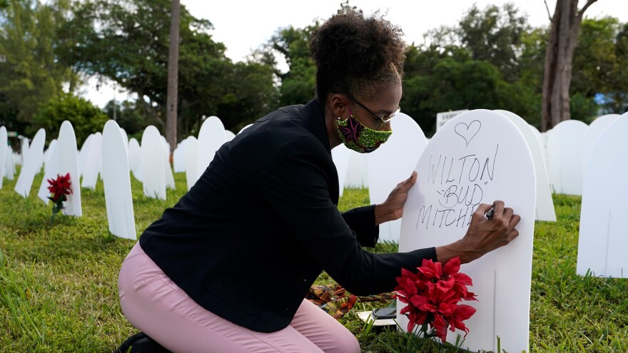 Rachel Moore writes a tribute to her cousin Wilton "Bud" Mitchell who died of COVID-19 at a symbolic cemetery created to remember and honor lives lost to COVID-19, in the Liberty City neighborhood of Miami.