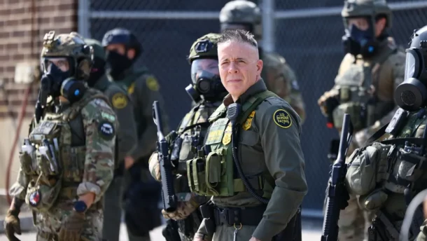 Gregory Bovino, chief patrol agent of the U.S. Border Patrol’s El Centro Sector who led ICE enforcement operations in Los Angeles, stands with law enforcement officers during a clash with protesters Friday outside the ICE facility in Broadview.
