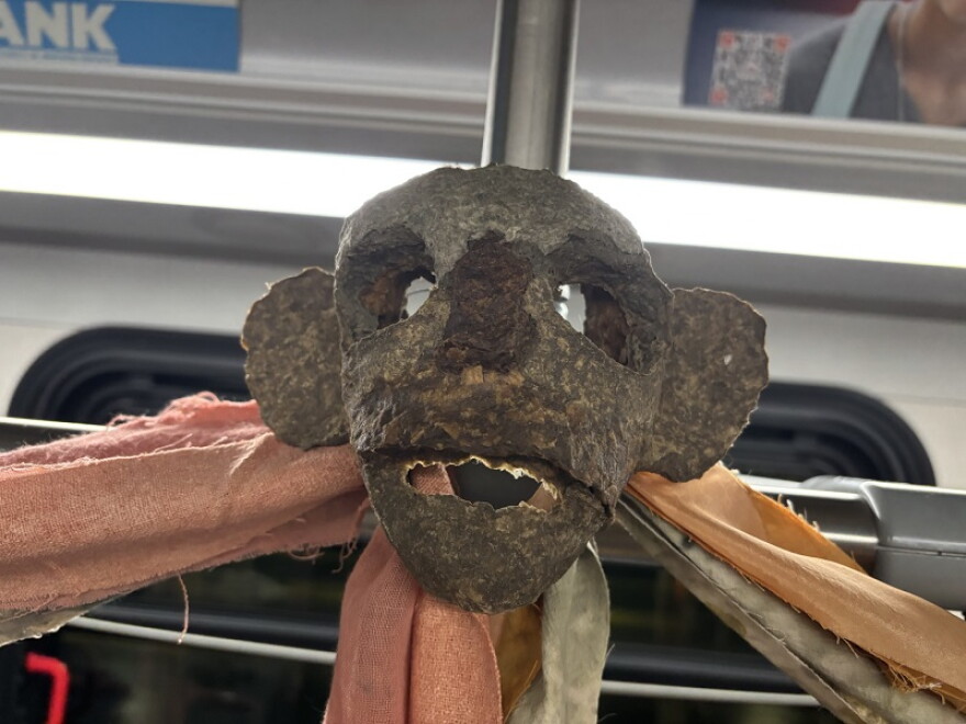 Masks made by artist Ethan Machell were visible on the environmental rainbow bus.