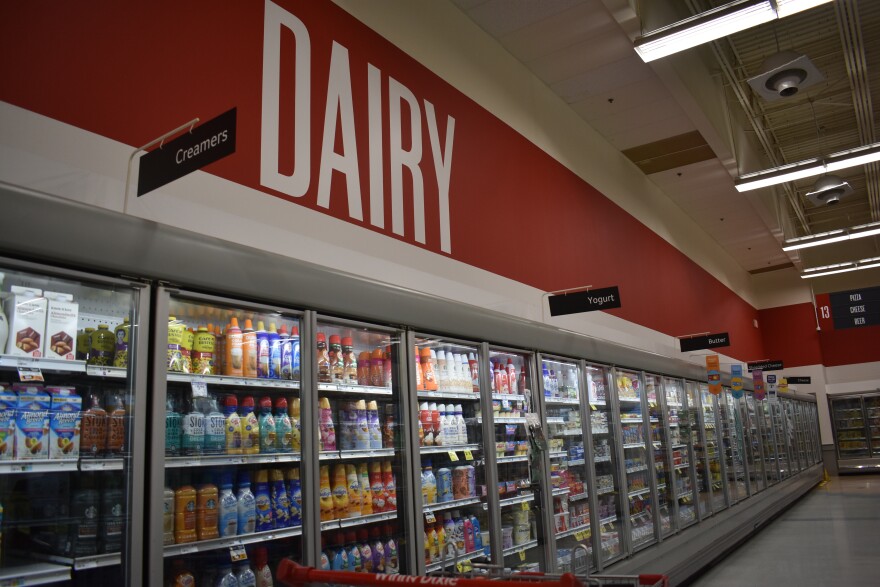 A sign reads "Dairy" in a refrigerated aisle at Winn-Dixie.