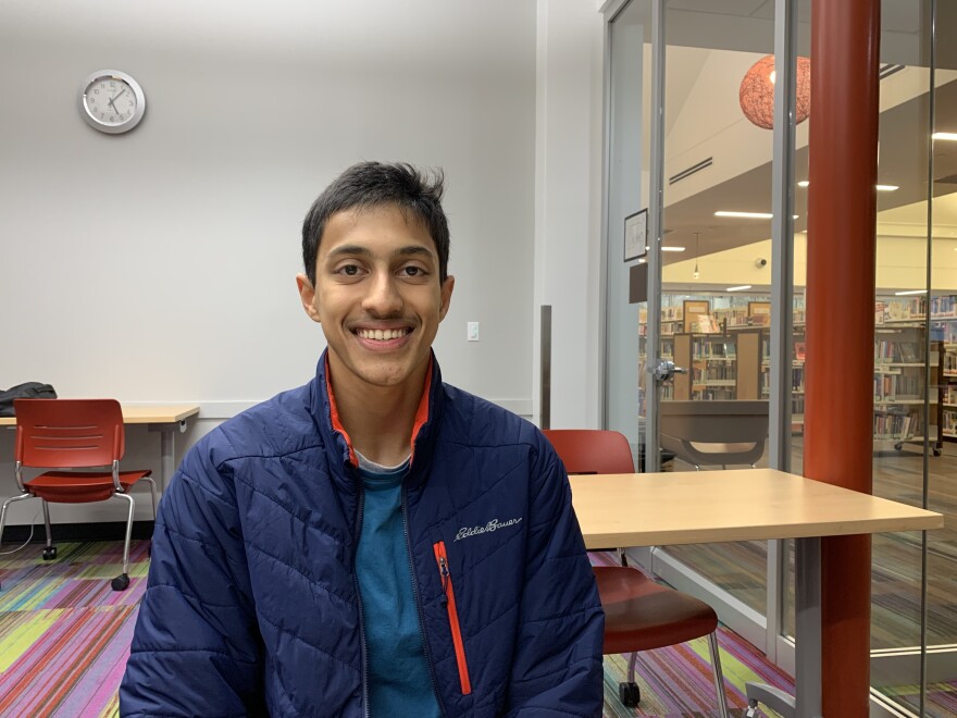 IMG_1198.JPG Smiling young man, a high school senior with a blue jacket, in a room by himself in a public library