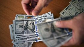 This illustration shows a man counting US dollars in Caracas, Venezuela.