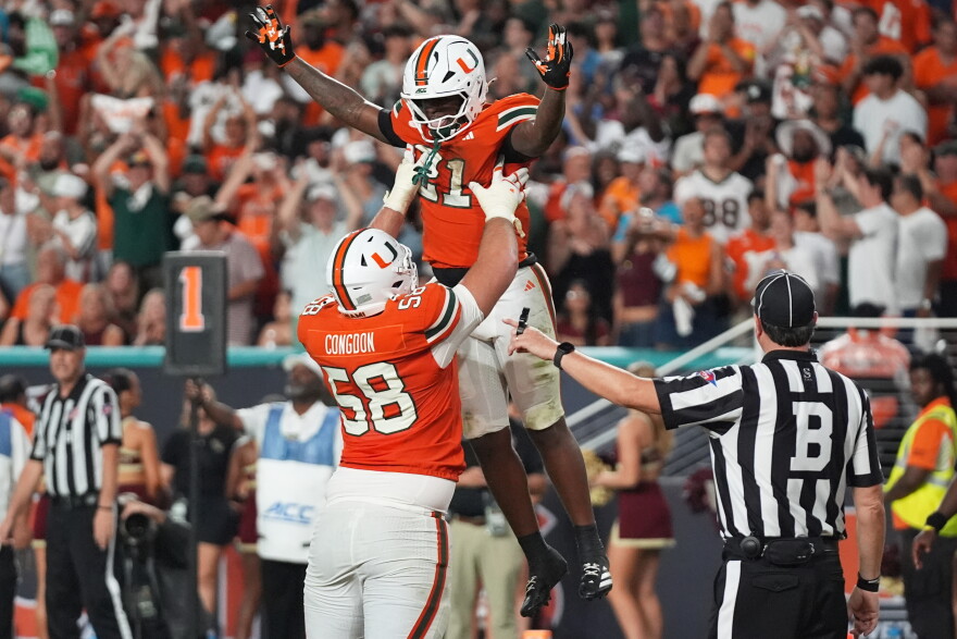 Miami running back Javian Mallory (21) celebrates with offensive lineman Ben Congdon (58) after scoring a touchdown during the second half of an NCAA college football game against Florida State, Saturday, Oct. 17, 2026, in Miami Gardens, Fla.