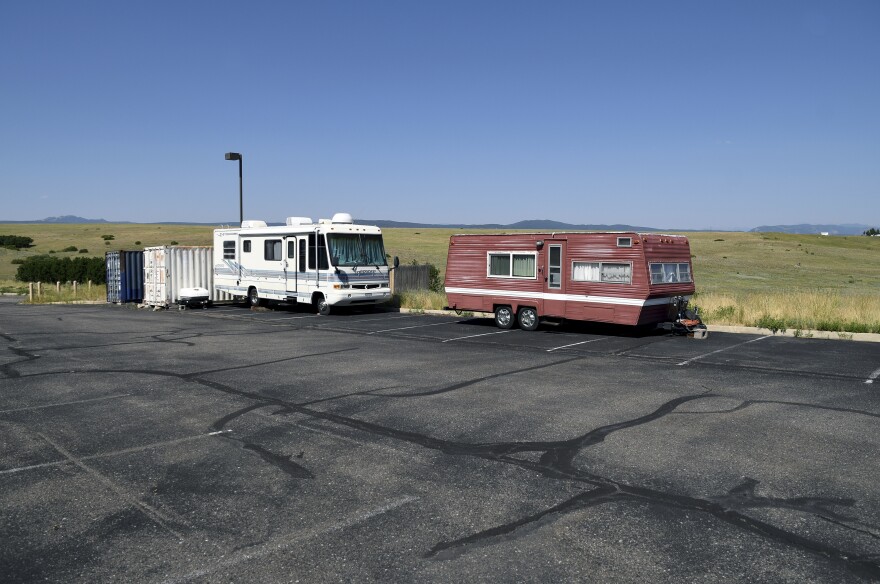 An RV and camping trailer sit in a church parking lot.