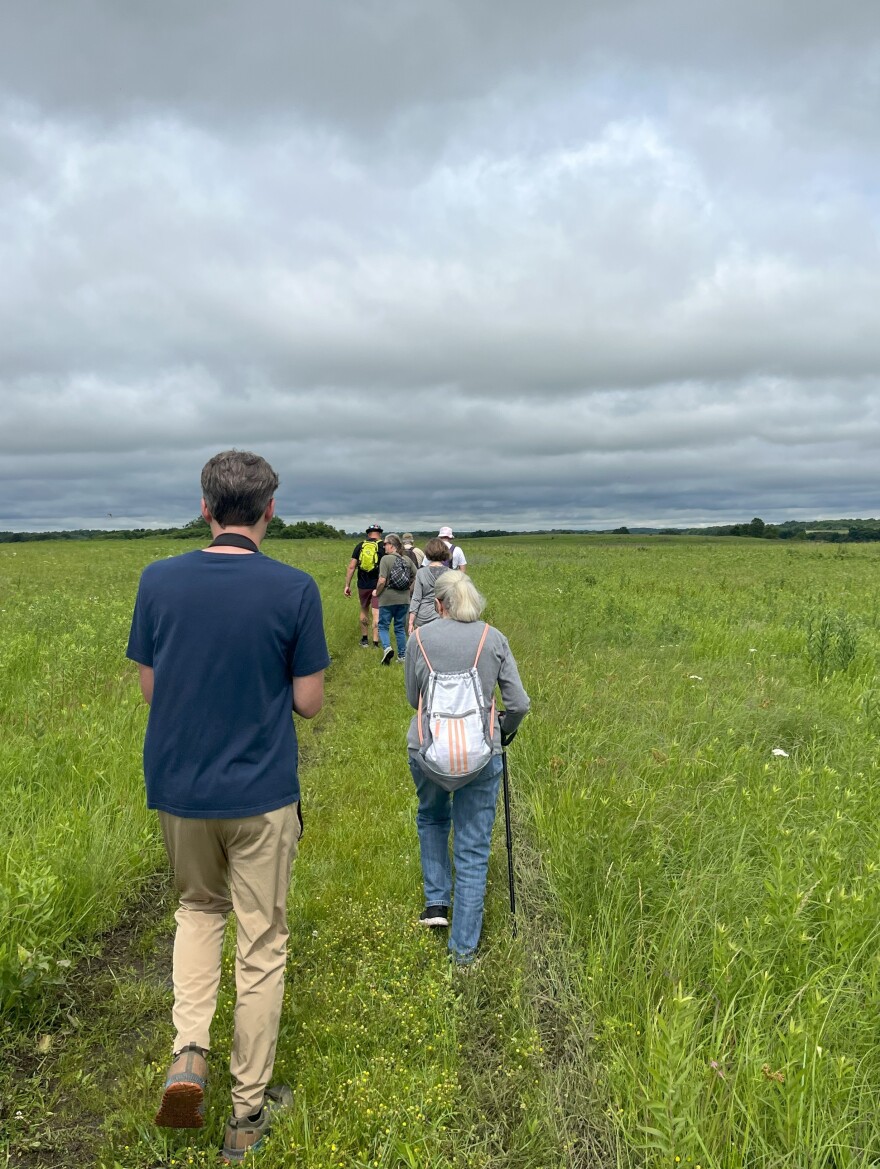 Visitors walk on one of the hiking trails before trekking through the tallgrass.