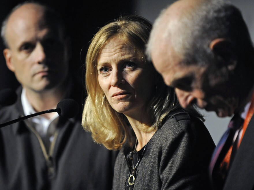 Mary Wittenberg, president of the New York Road Runners, announces the cancellation of the maration Friday in New York with Deputy Mayor Howard Wolfson (left) and George Hirsch, chairman of the board of New York Road Runners.