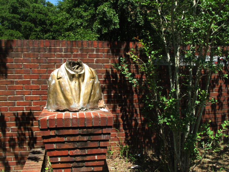 A vandalized bust remains on display at what was the Africatown Welcome Center in Mobile, Ala.