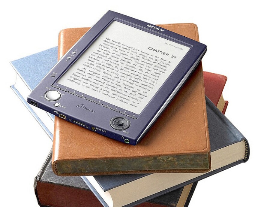 an e-reader on top of a stack of books