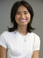 A person sits against a gray background looking at the camera.
