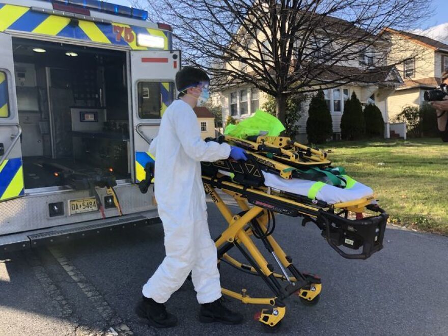 Teaneck Volunteer Ambulance Corps member Bobby Alexiou, 20, wheels out a stretcher outside the home of a potential COVID-19-positive patient in Teaneck, N.J., after suiting up in a protective suit, donated goggles from the local high school and an N95 mask.