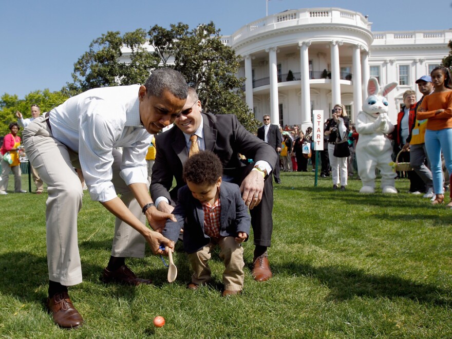 President Barack Obama helps a young participant roll an egg during the White House Easter Egg Roll on the South Lawn of the White House on April 9, 2012 in Washington, DC.