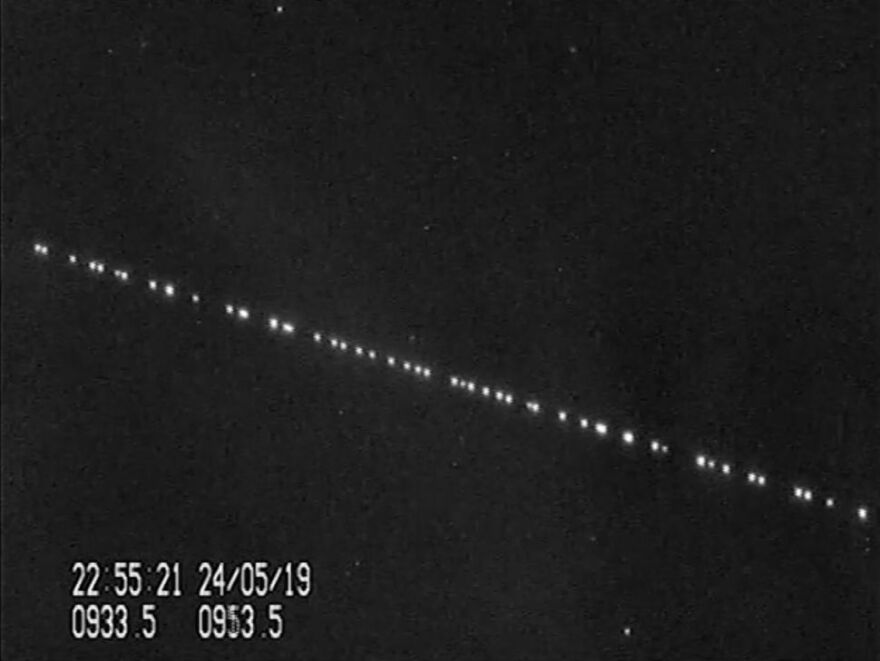 A train of SpaceX Starlink satellites in the night sky.