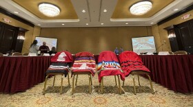 Members of the U.S. government's Not Invisible Commission prepare for a field hearing in Albuquerque, N.M. on Wednesday, June 28, 2023. Four skirts were placed at the front of the room to honor Native Americans who have gone missing or have been trafficked or killed. The commission will be crafting recommendations to improve coordination among agencies and to establish best practices for state, tribal and federal law enforcement. (AP Photo/Susan Montoya Bryan)