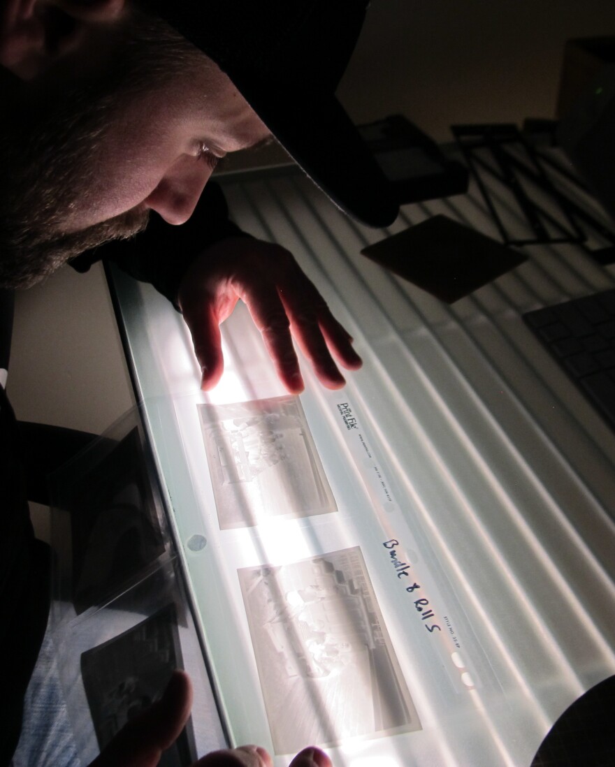 Levi Bettwieser examines some recently developed film at the light table in his basement.