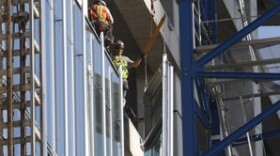 Workers install a glass panel on the new Bank of Oklahoma building in downtown Oklahoma City, August 26, 2016. 