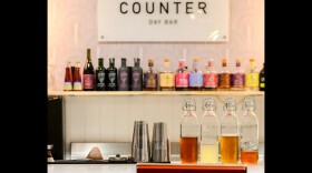 Image of a bar with non-alcoholic drinks lined up on a shelf.