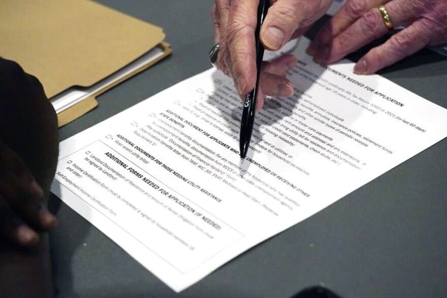 An applicant, left, is assisted by a volunteer with filling out the paperwork needed at a rental assistance fair. (AP Photo/Rogelio V. Solis)