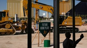 FILE - A person takes a picture near construction equipment during a groundbreaking ceremony for the Athletics' baseball stadium Monday, June 23, 2025, in Las Vegas. (AP Photo/John Locher, File)