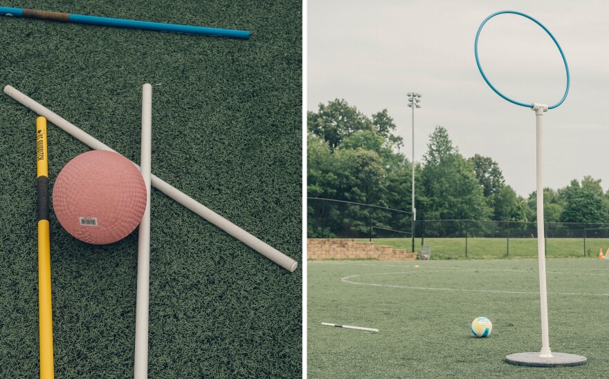 Quidditch's requisite sticks lie on a field, or pitch, next to a bludger, or a dodgeball in the real-life game. One of the scoring hoops — there are three — are set up on the pitch.