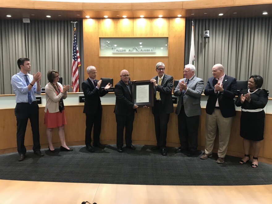Retiring City Engineer Gene Brown (center left) receives the congratulations of the Normal Council for his decades of service.