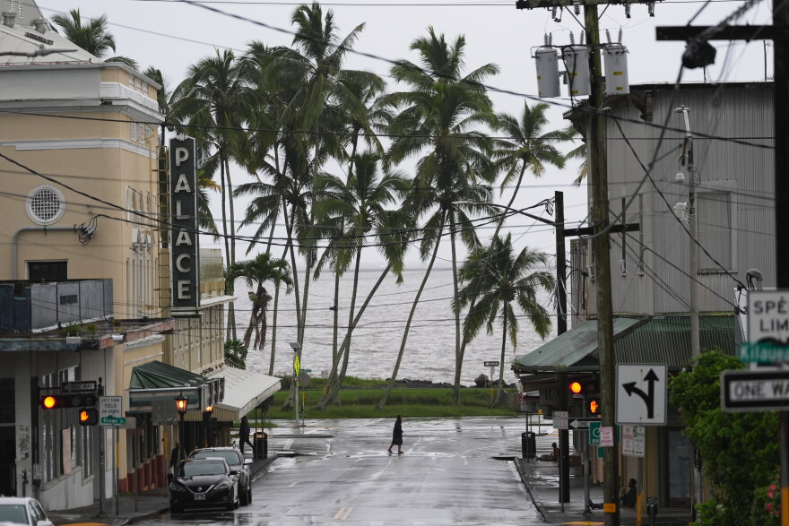 A man crosses the road as Hurricane Nolo sits nearby Saturday, Sept. 26, 2026, in Hilo, Hawaiʻi.