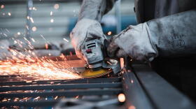 A person works with a manufacturing tool.